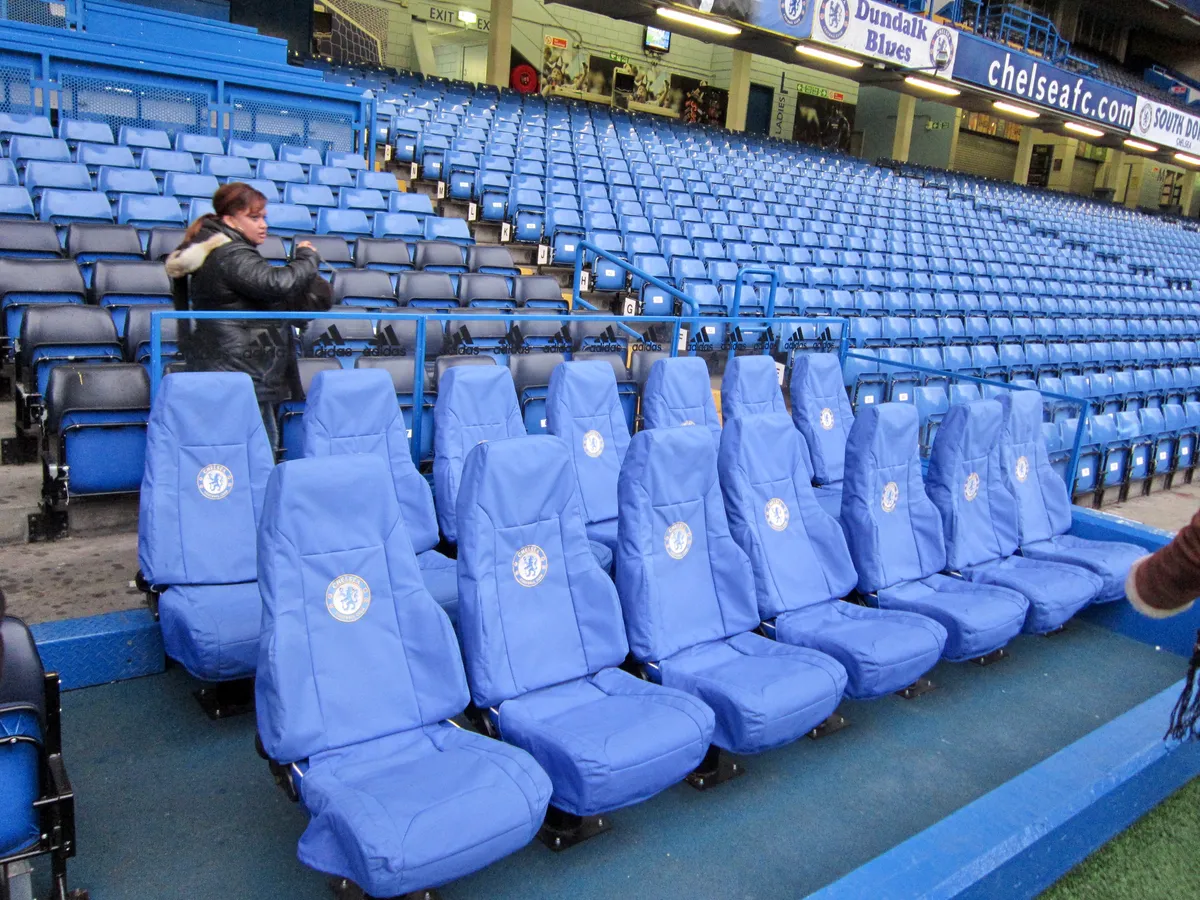 Kuddfodrade blå båsplatser vid planranden under en Chelsea stadiontur på Stamford Bridge i London
